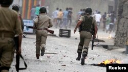 Indian police chase protesters during a strike called by separatist groups over killings in south Kashmir, Sep. 21, 2013. 
