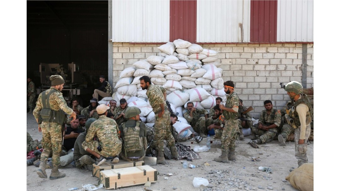 Turkish soldiers and Turkish-backed Syrian rebels gather near the Syrian border town of Ras al-Ayn, Oct. 12, 2019, as Turkey and its allies continued their assault on Kurdish-held border towns in northeastern Syria.