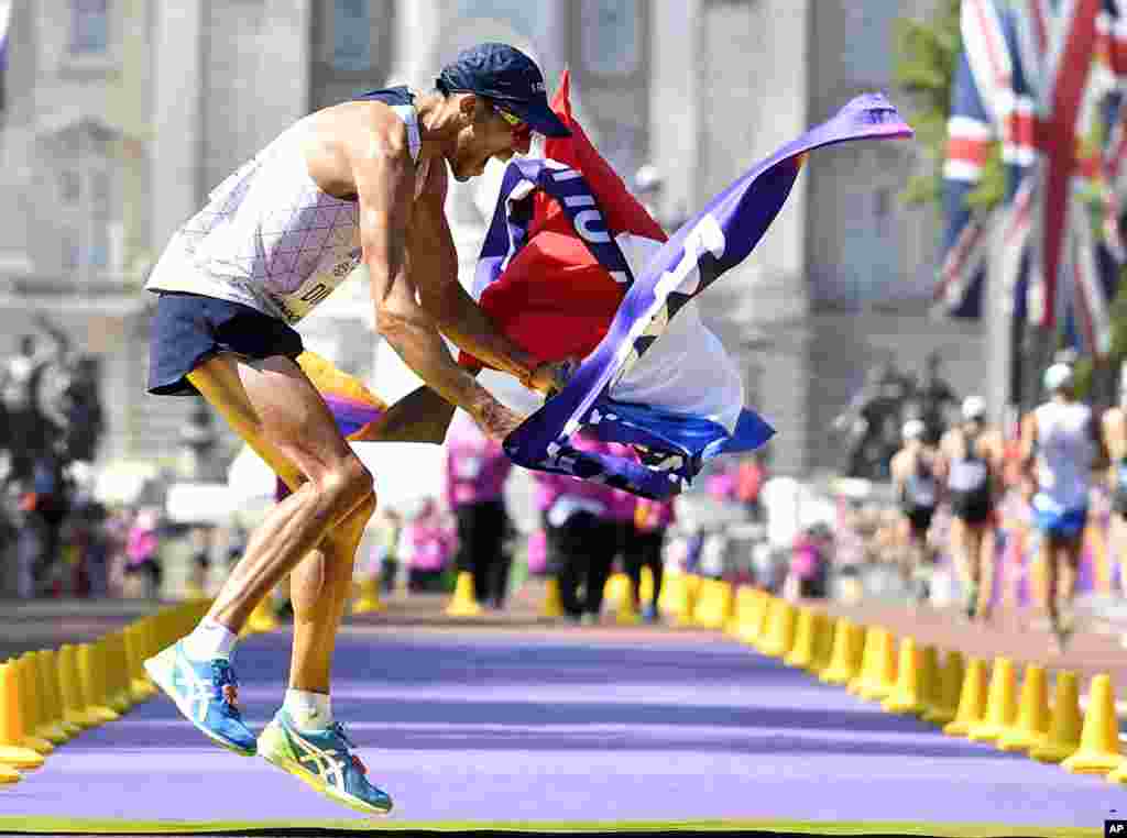 France's Yohann Diniz celebrates after crossing the line to win the gold medal in the men's 50-kilometer race walk during the World Athletics Championships in London.