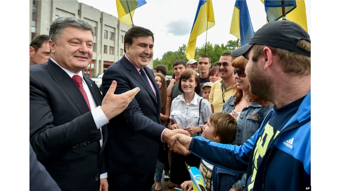 FILE - Seen during better times, Ukrainian President Petro Poroshenko, left, and then newly-appointed Odesa region governor Mikheil Saakashvili, second left, shake hands with local residents, in Odesa, Ukraine, May 30, 2015.