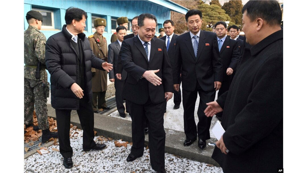 Head of North Korean delegation Ri Son Gwon, center, is greeted by South Korean officials after he crosses the border line to attend their meeting at Panmunjom in the Demilitarized Zone in Paju, South Korea, Jan. 9, 2018.