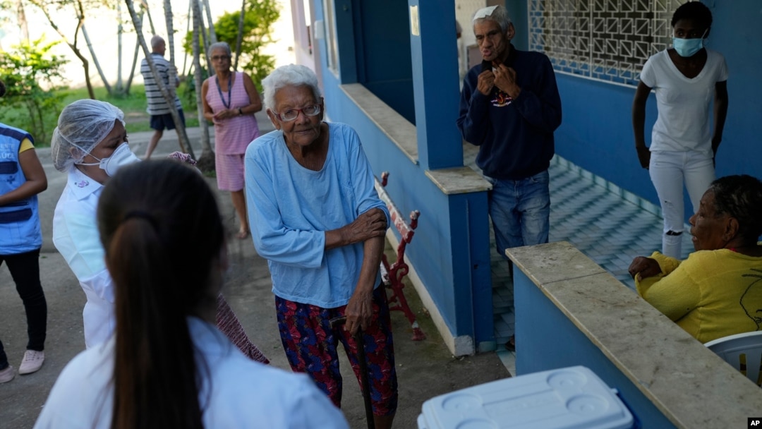 FILE - An elderly woman waits to get a dose of the Pfizer COVID-19 vaccine at Casa de Repouso Laco de Ouro nursing home, in Rio de Janeiro, Brazil, Sept. 2, 2021.