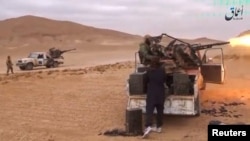 A still image taken on December 11, 2016 from a video released by Islamic State-affiliated Amaq news agency on Dec. 10, 2016, purports to show Islamic State fighters advancing over the Hayan mountain south of Palmyra. 