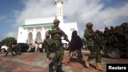 FILE - Soldiers serving in the African Union Mission in Somalia (AMISOM) patrol outside a Mosque during Eid al-Fitr prayers, marking the end of the fasting month of Ramadan at a Mosque in Somalia's capital Mogadishu, July 17, 2015.