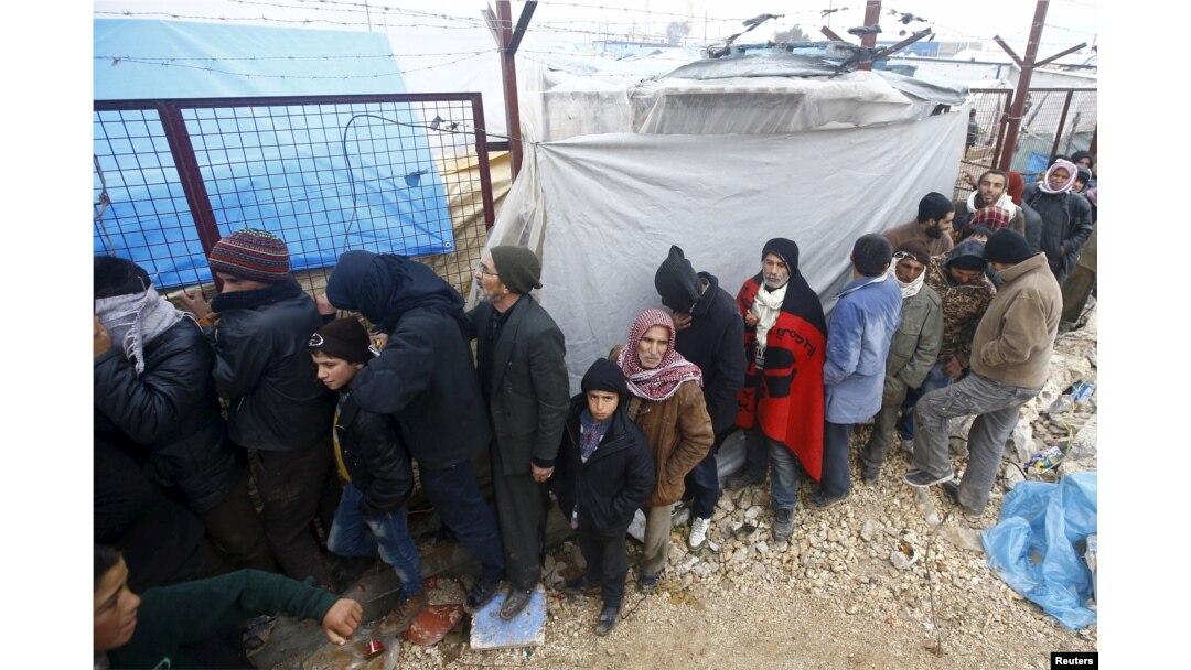 FILE - Internally displaced Syrians line up to receive blankets near the Bab al-Salam crossing, across from Turkey's Kilis province, on the outskirts of the northern border town of Azaz, Syria, Feb. 6, 2016.