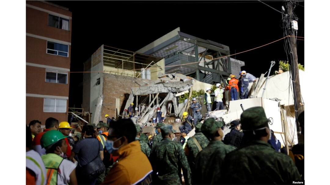 Rescue workers search through rubble during a floodlit search for students at Enrique Rebsamen school in Mexico City, Mexico, Sept. 20, 2017.