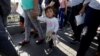 Migrant families from Mexico, fleeing violence, enter the United States to meet officers of the U.S. Customs and Border Protection to apply for asylum at Paso del Norte international border crossing bridge in Ciudad Juarez, June 20, 2018.