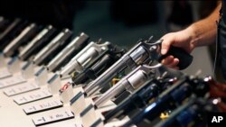 FILE - Handguns are displayed at the Smith & Wesson booth at the Shooting, Hunting and Outdoor Trade Show in Las Vegas, Jan. 19, 2016. 