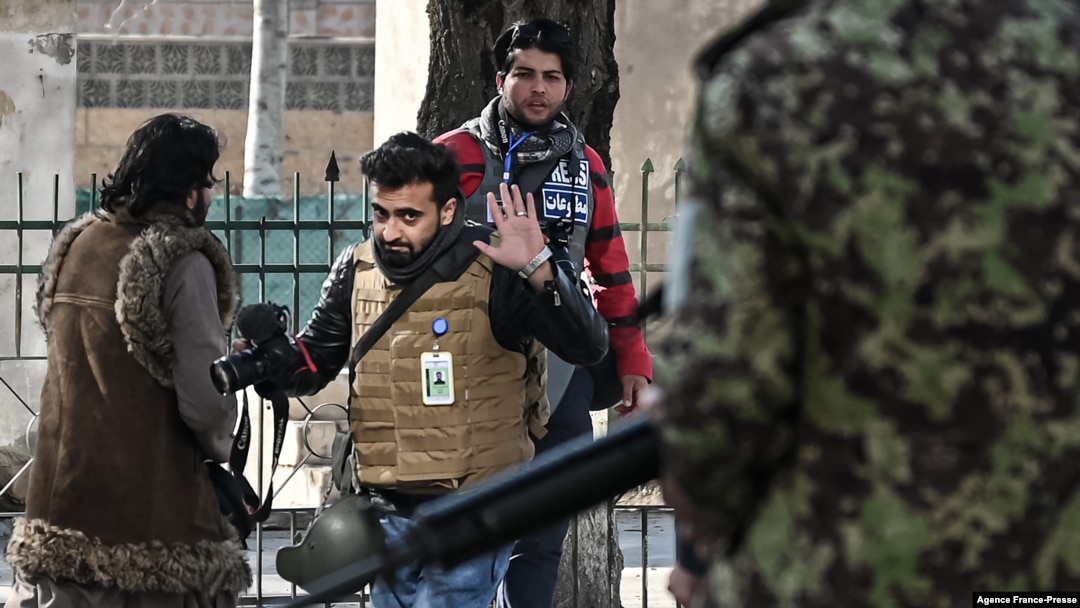 FILE - Taliban fighters walk toward journalists during a protest in Kabul, Afghanistan, Dec. 28, 2021.