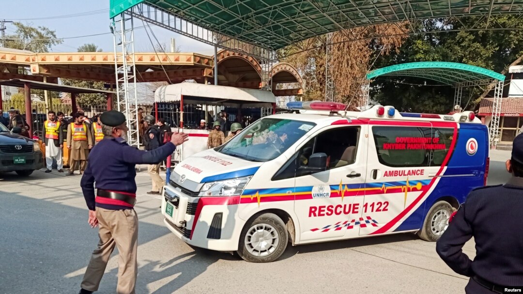 A police officer guides an ambulance after a suicide blast in a mosque, at police line area in Peshawar, Pakistan Jan. 30, 2023.