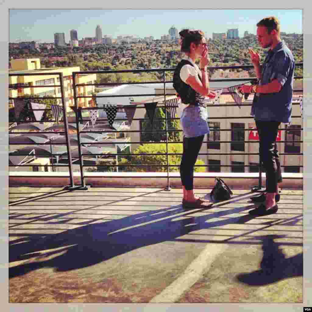 A young couple in front of the skyline of the Sandton business district.