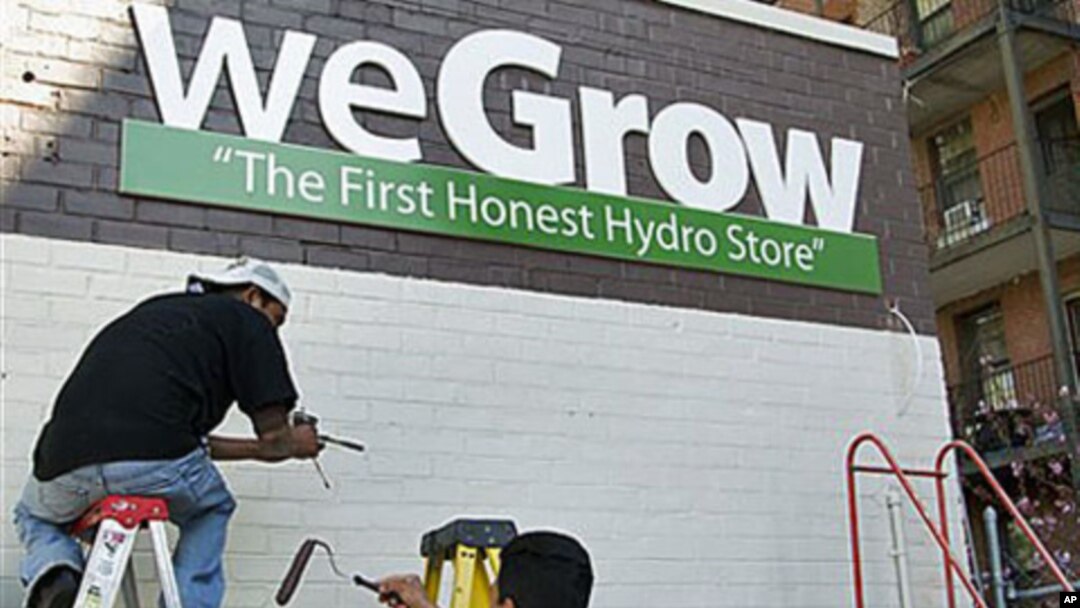 Workers put the finishing touches on the side of a building that will house a weGrow store in preparation for its opening on April 6, in northeast Washington, DC, March 29, 2012.