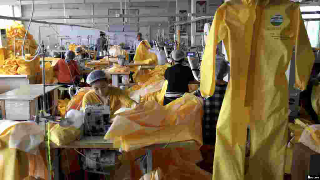 "Lakeland Industries" kompaniyasi ishchilari himoya kiyimlarini tayyorlamoqda, Shandong provinsiyasi, Xitoy, 28-oktabr, 2014-yil.