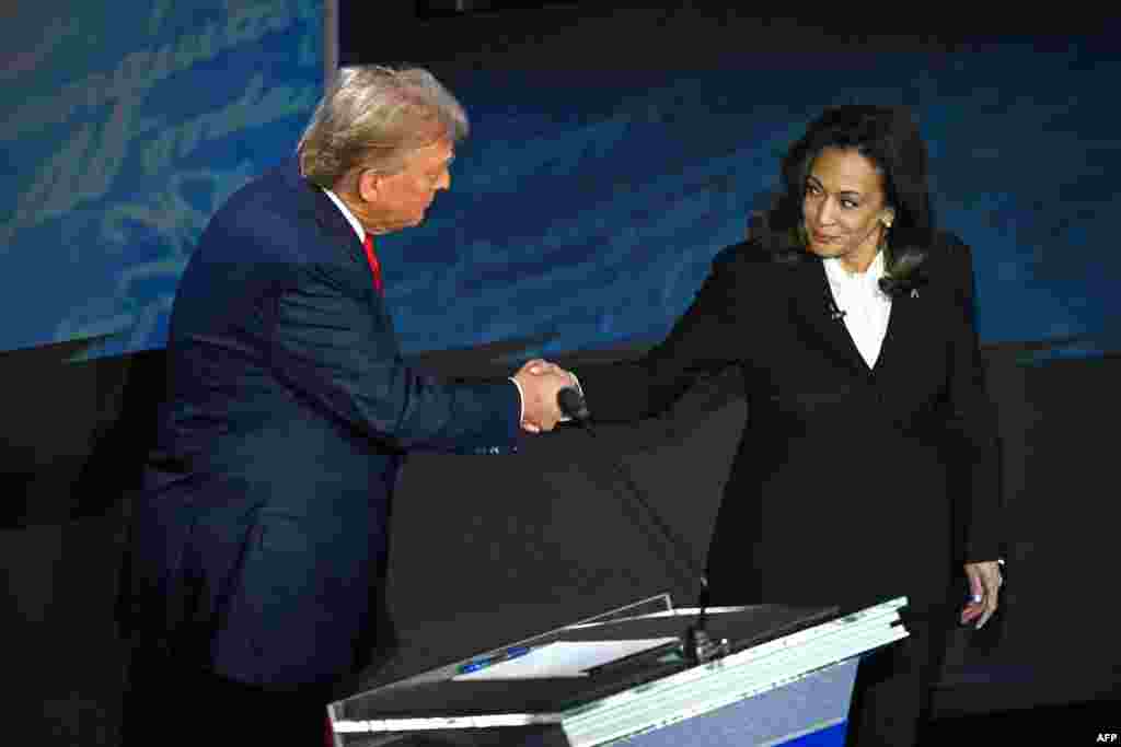 Mokonzi ya kala ya ekolo Amerika Donald Trump (G) na Vice-présidente mpe démocrate Kamala Harris (D) na libandeli lya bondongwani na bango na etando eke na National Constitution Center, Philadelphie, Pennsylvanie, 10 sanza ya libwa 2024.(Photo by SAUL LOEB / AFP)