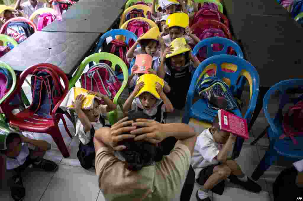 Schoolchildren from the Corazon Aquino Elementary School participate in a nationwide simultaneous earthquake drill in Manila, Philippines.