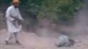 This still image taken from undated video footage depicts a man Afghan officials identified as a member of the Taliban firing his rifle at a woman accused of adultery during her execution in a village outside Kabul, Afghanistan.