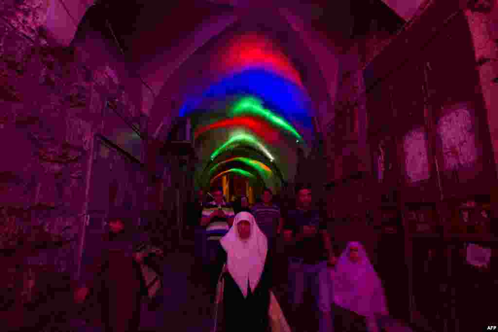 Palestinians walk before attending the evening prayer during the Muslim fasting month of Ramadan at the Al-Aqsa mosque compound in the old city of Jerusalem, July 9, 2013.