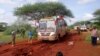 Kenyan security forces and others gather around the scene on an attack on a bus about 50 kilometers outside the town of Mandera, near the Somali border in northeastern Kenya, Nov. 22, 2014.