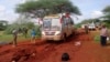 Kenyan security forces and others gather around the scene on an attack on a bus about 50 kilometers (31 miles) outside the town of Mandera, near the Somali border in northeastern Kenya, Nov. 22, 2014.