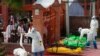 Family members watch as Nepalese army personnel in protective suits prepare the bodies of COVID-19 victims for cremation, near Pashupatinath temple, in Kathmandu, Nepal, May 7, 2021.