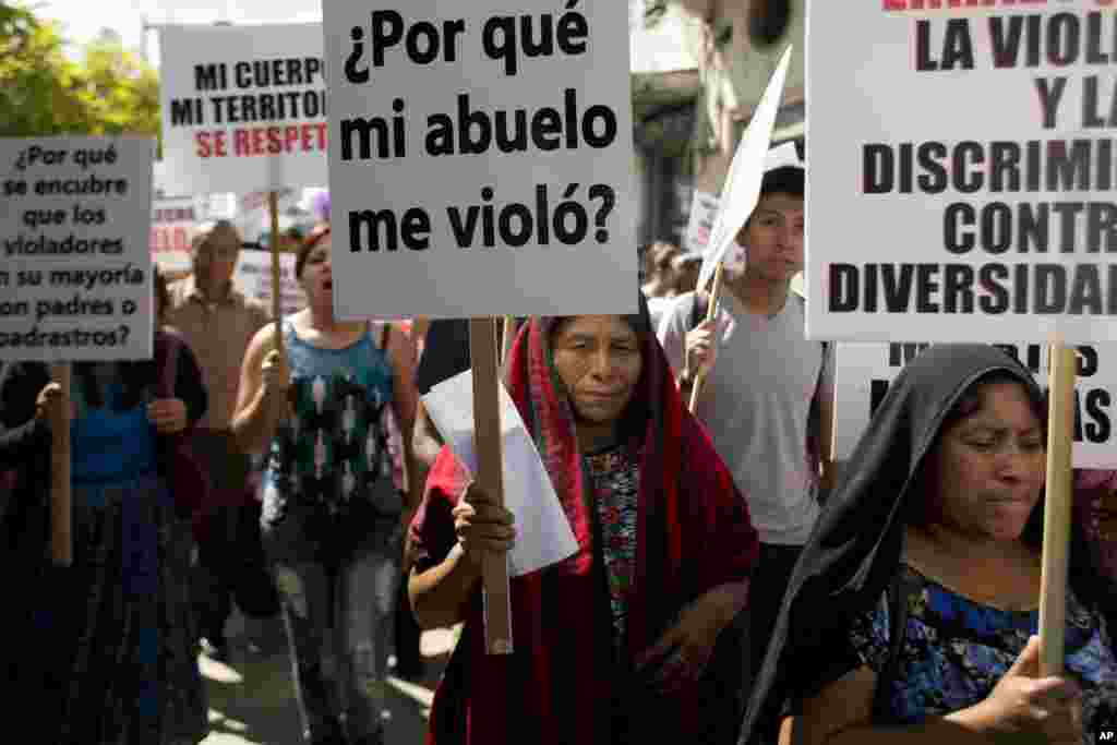 An indigenous woman carries a sign that says in Spanish "Why did my grandfather rape me?" during a march on International Day for the Elimination of Violence Against Women, in Guatemala City, Nov. 25, 2016.
