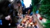 FILE - Warsaw residents place candles in front of the national Border Guards Headquarters in Warsaw, Poland, as a sign of mourning for four migrants found dead over the weekend along the border between Poland and Belarus, Sept. 20, 2021.