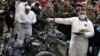 Investigators inspect parts of a destroyed car at the site of a car bombing in Beirut, Jan. 21, 2014.