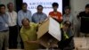 Occupy Central activists including Chung Kim-wah, left, and Robert Chung, right, empty a ballot box after a referendum on democratic reforms in Hong Kong, June 29, 2014. 
