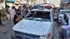 Police officers examine a damaged police vehicle at the site of bomb blast, in Quetta, Pakistan, Monday, April 10, 2023.