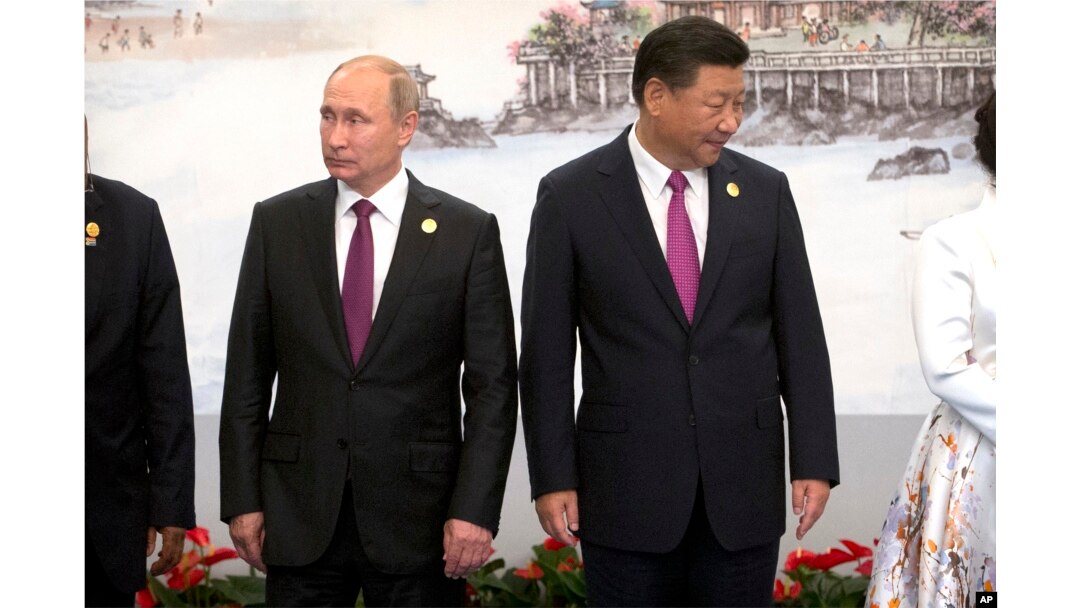 Russian President Vladimir Putin, left, and Chinese President Xi Jinping line up for a photo during the BRICS Summit in southeastern China's Fujian province, Sept. 4, 2017.