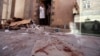A doctor points at blood inside the hospital at the scene of the attack during a tour for journalists and survivors at the Defense Ministry in Sana'a Dec. 19, 2013.