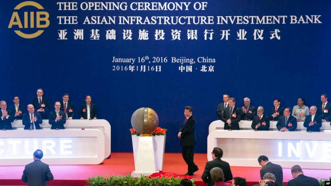 FILE - Representatives of the founding nations of the Asian Infrastructure Investment Bank (AIIB) applaud as Chinese President Xi Jinping, center, unveils a sculpture during the opening ceremony of the AIIB in Beijing, Jan. 16, 2016.