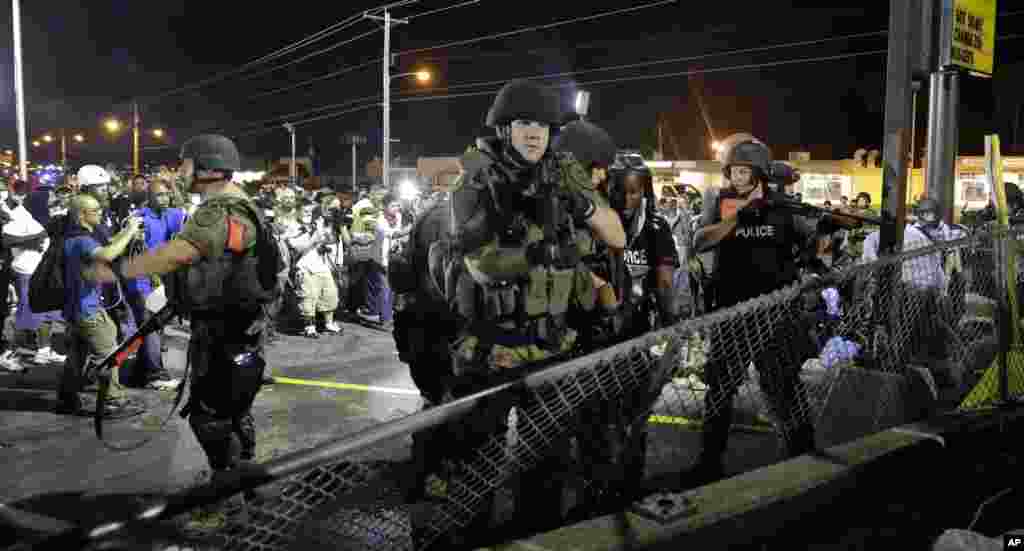 Police try to disperse a crowd in Ferguson, Missouri, early Aug. 20, 2014.