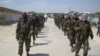 FILE - Members of Somalia's al-Shabab militant group patrol on foot on the outskirts of Mogadishu, Somalia, March 5, 2012.