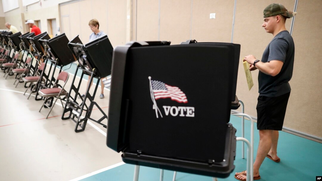 Voters cast their ballots in a polling station at Quest Community Church, Aug. 7, 2018, in Westerville, Ohio.