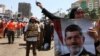 Egyptian supporters of Muslim Brotherhood and Egypt's ousted president Mohamed Morsi [pictured on poster] take part in a self-defense training outside Rabaa al-Adawiya mosque in Cairo, July 16, 2013.
