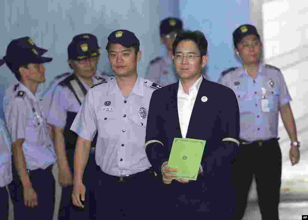 Lee Jae-yong, second from right, vice chairman of Samsung Electronics Co., arrives for his trial at the Seoul Central District Court in Seoul, South Korea. Prosecutors recommended imprisoning a billionaire Samsung heir for 12 years, asking court to convict him of bribery and other crimes in a national corruption scandal.