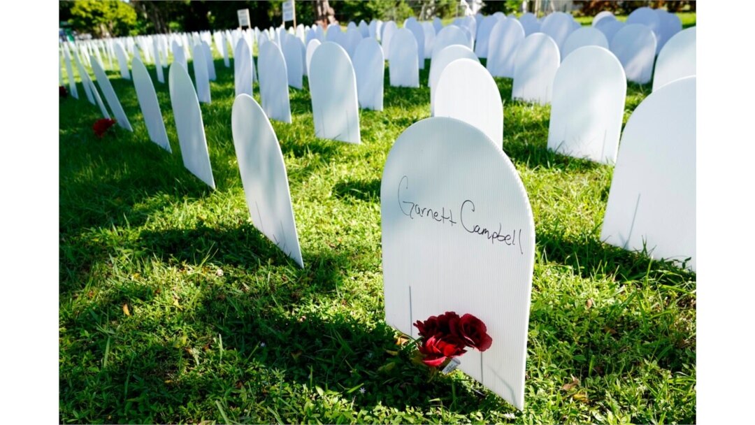 White plastic tombstone-shaped pieces are lined up as a temporary memorial to some of Miami's victims of the coronavirus at Simonhoff Floral Park, Oct. 14, 2020, in the Liberty City neighborhood of Miami.