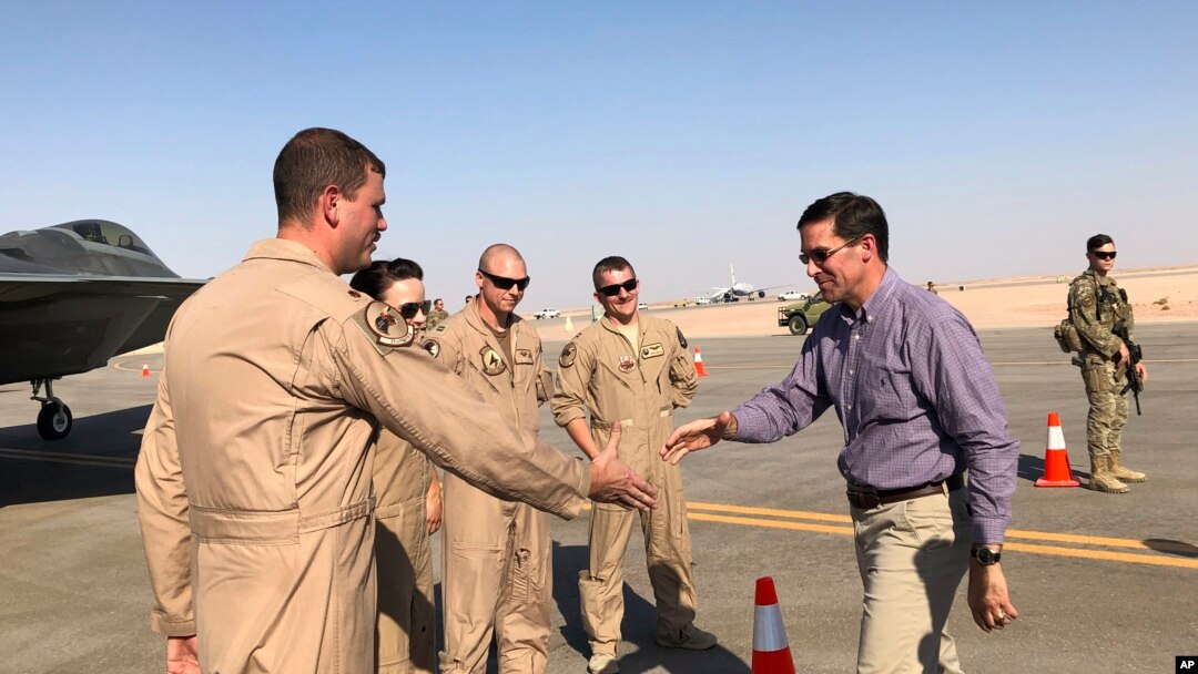 Defense Secretary Mark Esper talks with U.S. troops in front of an F-22 fighter jet deployed to Prince Sultan Air Base in Saudi Arabia, Tuesday, Oct. 22, 2019.