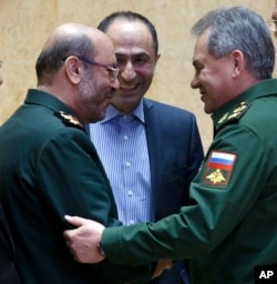 FILE -- Russian Defense Minister Sergei Shoigu, right, and Iranian Defense Minister Hossein Dehghan shake hands during a meeting in Moscow, Russia, Feb. 16, 2016.
