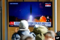 Seulda odamlar Shimoliy Koreya raketa sinovlarini tomosha qilmoqda, 12-yanvar, 2022