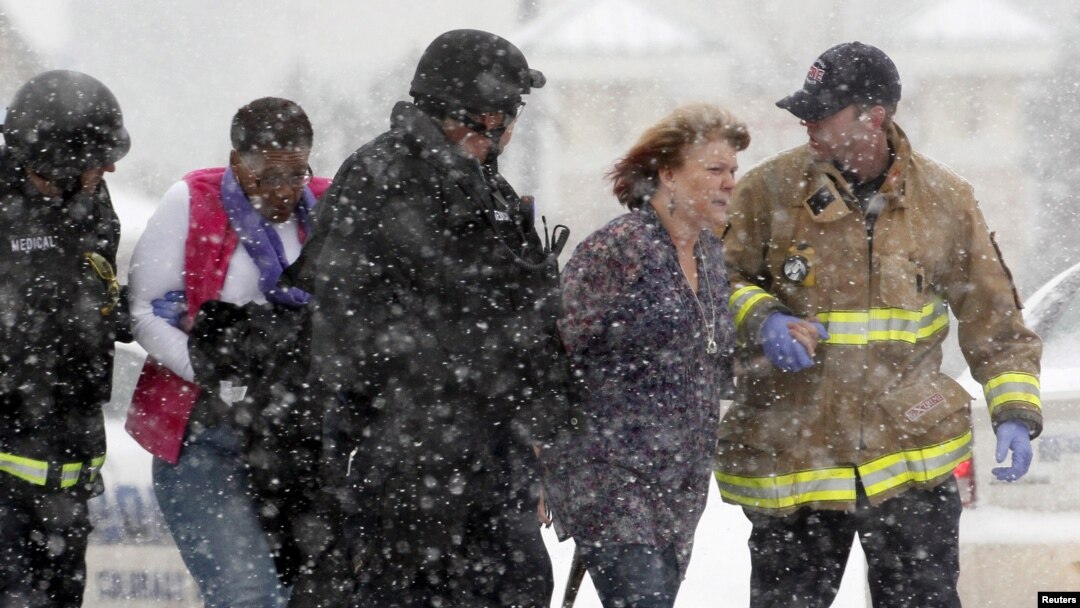 Two women are evacuated from a building where the shooter was suspected to be holed up.