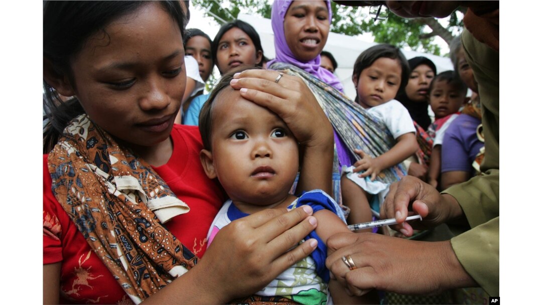 FILE - An Indonesian child receives a shot of measles vaccine in Banyusoco village near Gunung Kidul, Indonesia.