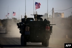 FILE - A convoy of U.S. forces armored vehicles drives near the village of Yalanli, on the western outskirts of the northern Syrian city of Manbij, March 5, 2017.