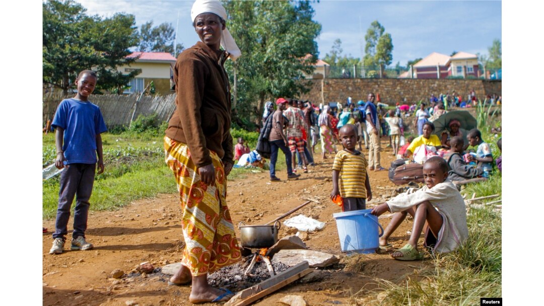 A refugee from the Democratic Republic of the Congo is seen with her children as they prepare a meal near the U.N. High Commissioner for Refugees offices in Karongi district, Rwanda, Feb. 21, 2018.