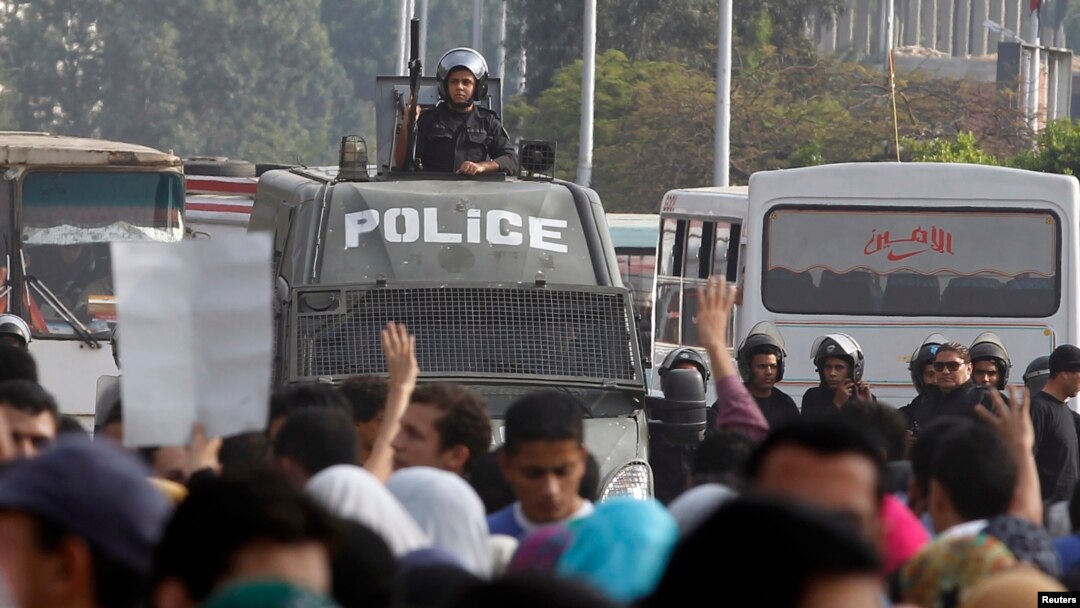 Protesters gesture with four fingers after blocking Al Nasr street in front of Al-Azhar University headquarters at Cairo's Nasr City district, Nov. 19, 2013.