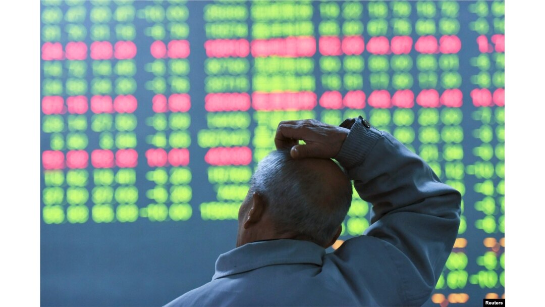 FILE - An investor looks at an electronic screen showing stock information at brokerage house in Hangzhou, Zhejiang Province, China, Jan. 11, 2016.