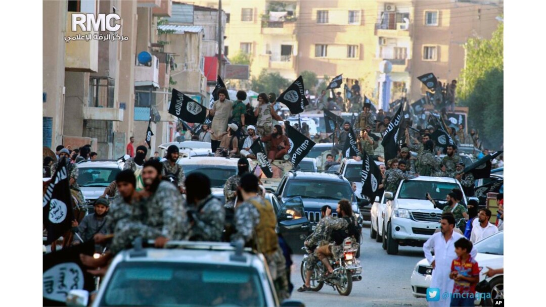 FILE - Fighters from the Islamic State group parade in Raqqa, north Syria, June 30, 2014. T0he U.S. says the IS fighting force is about one-third smaller now than it was in 2015.
