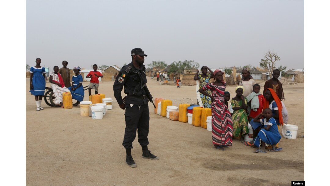FILE - A Cameroonian police officer enforces order in Minawao, Cameroon, March 15, 2016.
