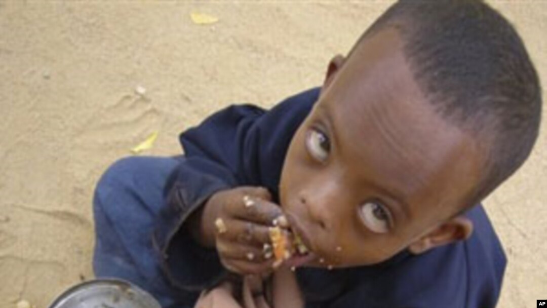 In this file photo of Thursday June 26, 2009, a Somali child eats as he is waiting to be registered at U.N. registration center in Dagahaley, Northeastern Kenya